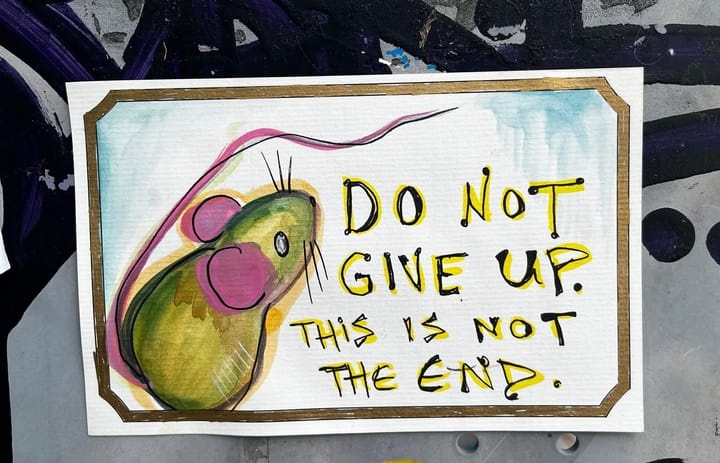 A painting of a mouse on a telephone box. Words in ink read: Do not give up this is not the end